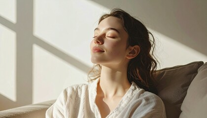 Serene woman basking in sunlight indoors with closed eyes.