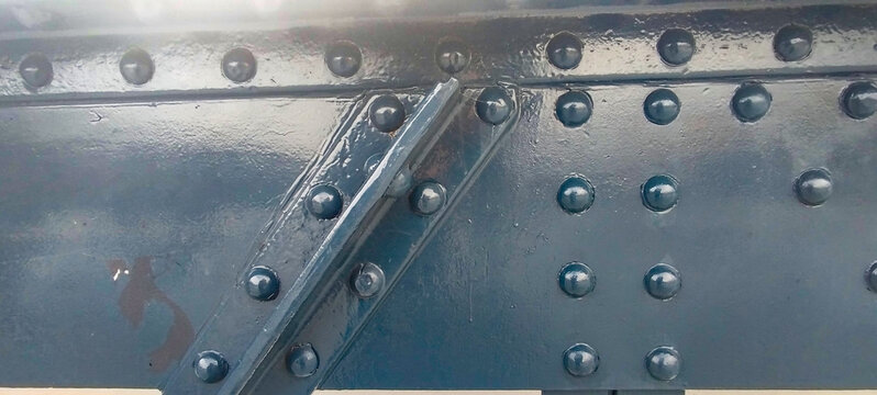 Estructura de acero industrial con remaches y placas met&aacute;licas pintadas de azul oscuro