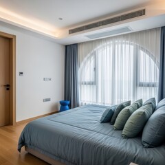 Modern bedroom with large windows and a view of the city skyline