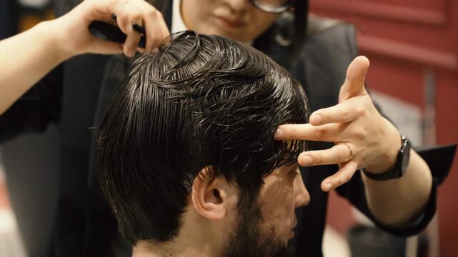 Close up of barber cutting man hair with professional comb