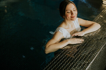 Woman enjoys relax time in a spa pool at a wellness center during daytime
