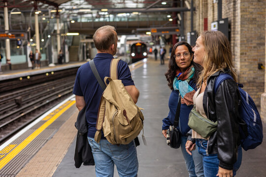 Three travelers waiting for the London train