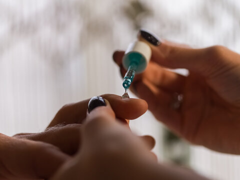 Woman applying cuticle remover on hand