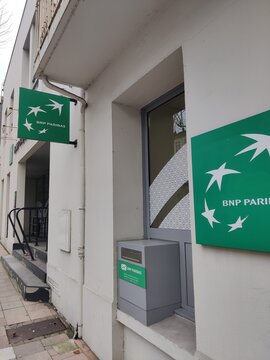 Saintes, France - January 28, 2026: BNP Paribas bank branch exterior with green signage and ATM visible, located in a modern urban setting