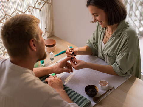 Man receiving manicure from loving wife 