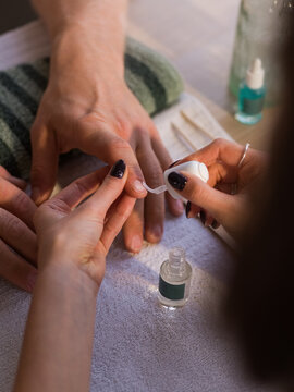 Manicurist applying cuticle remover 