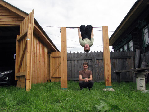 Young man hanging on horizontal bar