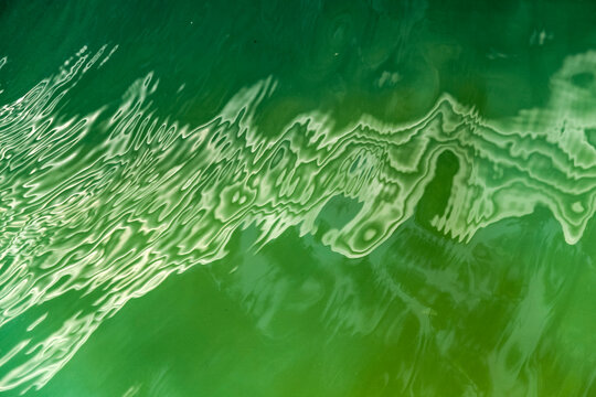 Distorted light reflection on green water