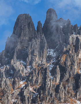 Dramatic winter view of Grignetta spires emerging from thick fog and low clouds. Moody alpine landscape with snow-covered rocky peaks in the Grigne mountains, Lecco, Italy - January 2026