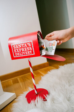 Hands put letter in a red mailbox marked for Santa's express delivery