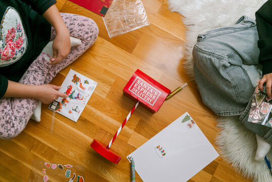 Children Create Letters For Santa on a Wooden Floor