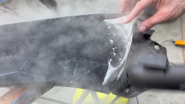 A car wrapping specialist applies a polyurethane film to the car. Selective focus. PPF protective film against chips and scratches. Anti-gravity protection. PFF is installed. Car wrapping close-up.