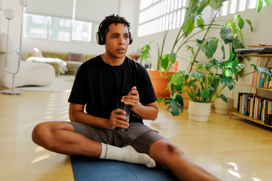 Man drinking protein shake after home workout