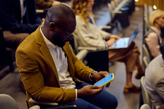Businessman uses his phone at the conference