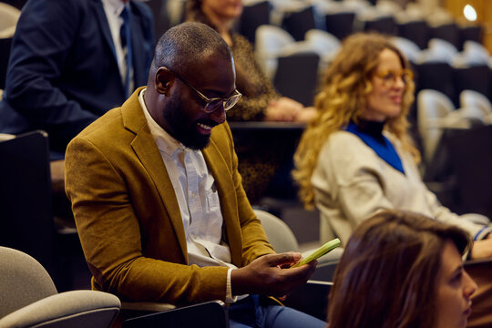 Businessman checks his phone during the conference