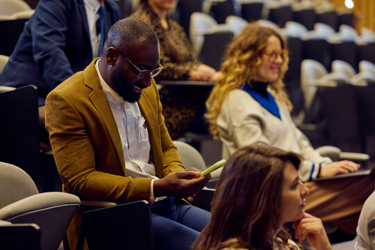 Businessman uses his phone at the conference