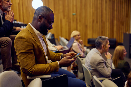 Businessman uses his phone on the seminar