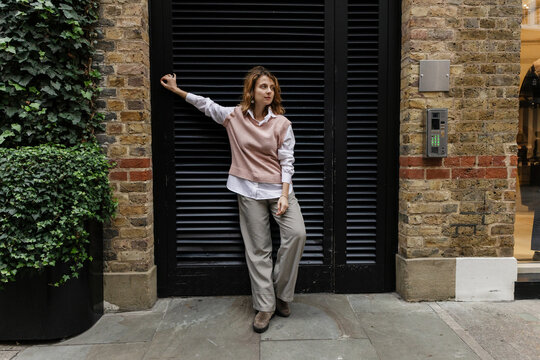 Woman posing on city street wearing casual fall fashion