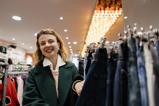 Woman smiling buying clothes in vintage retail store