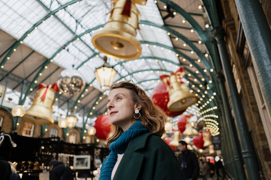 Woman enjoying festive Christmas decorations in Covent Garden London