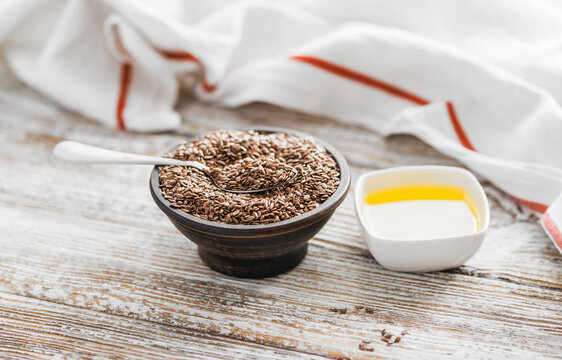 Organic linseed oil and seeds on rustic wooden surface, healthy nutrition.
