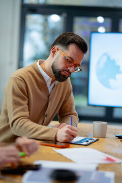Man writing notes during meeting
