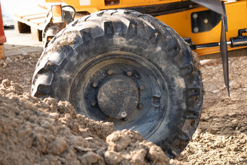 Closeup on wheel of an all terrain dumper on construction site.