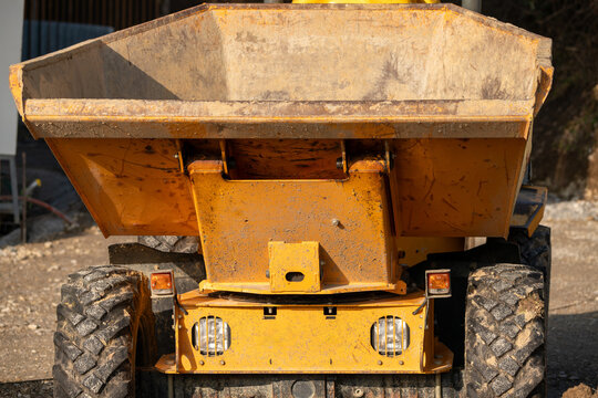 Closeup on yellow all terrain dumper on construction site. View from the front.