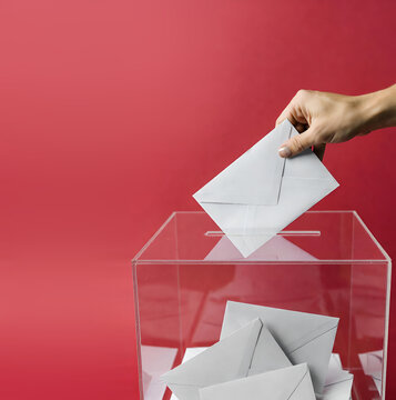 Main d&eacute;posant un bulletin de vote dans une urne transparente pour un scrutin officiel et d&eacute;mocratique