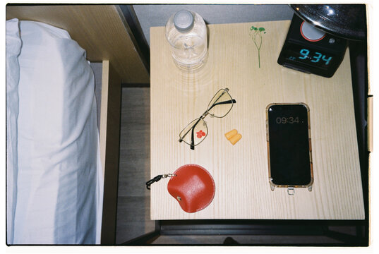 Various items on a bedside table in a hotel room