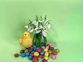 easter composition with colored candy and a chicken,. easter background.