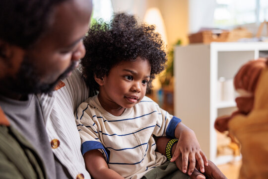 Father and child bonding over a puppet show.