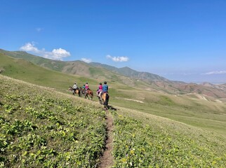 Obraz premium Horse riding in the breathtaking landscape of Song Kul Lake, Kyrgyzstan.