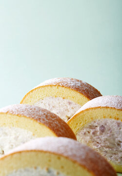 Closeup freshly baked taro cream cloud cake roll in green background