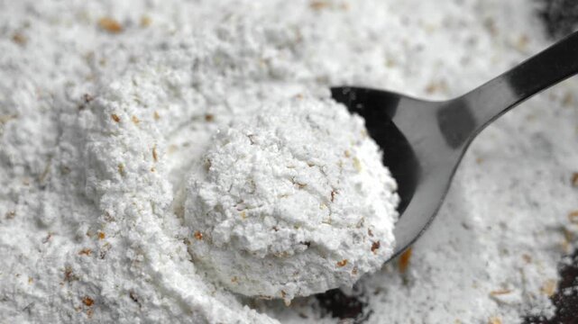 Fine sugar mixed with grated lemon zest in metal spoon. Baking ingredient