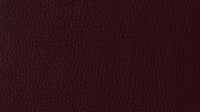 Texture of dark red or burgundy leather background close up view