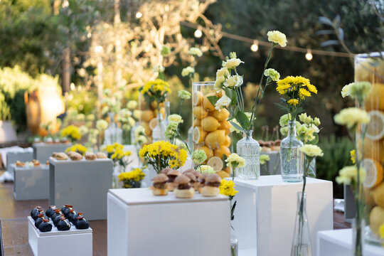 Elegant Outdoor Dessert Table with Yellow Flowers and Citrus Decor