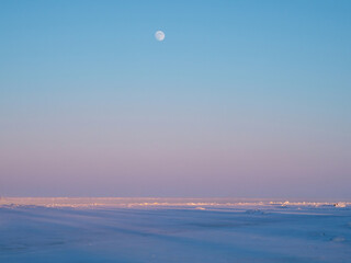 The moon rising over the frozen sea.