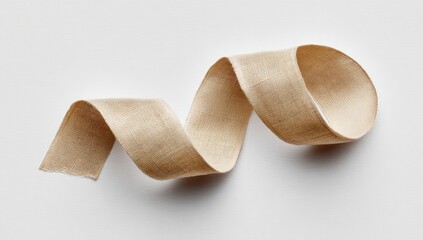 A tan, spiraling strip of cloth against a stark white backdrop, casting a shadow