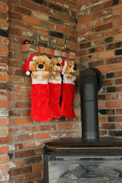 3 Stockings hung with JOY by brick fireplace