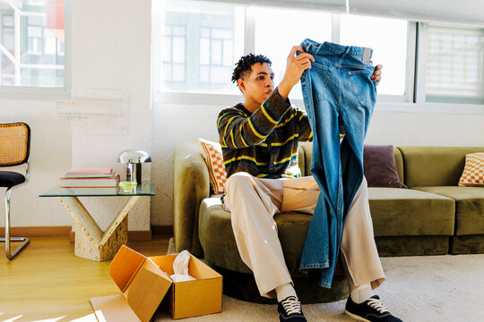 Man unpacking new blue jeans from an online purchase