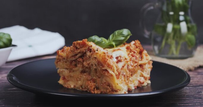 A fresh basil leaf atop a serving of lasagna, styled gourmet, restaurant concept, elegant food presentation for culinary and gastronomic projects
