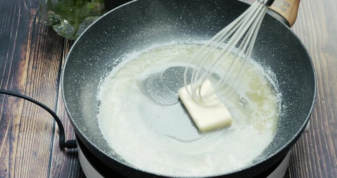 Butter melting in a hot pan, capturing the cooking process, food preparation, and culinary concept of homemade meals.