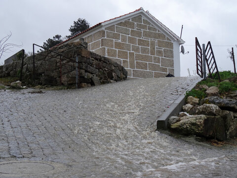 Enxurrada de &aacute;guas pluviais descendo rampa de acesso a moradia rural num dia de tempestade