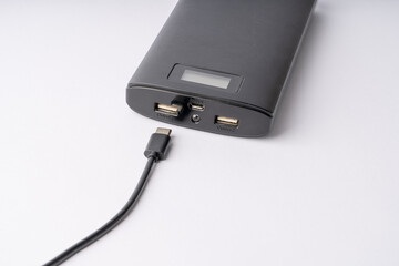 Obraz premium Modern Black Power Bank with USB-C Cable for Mobile Device Charging