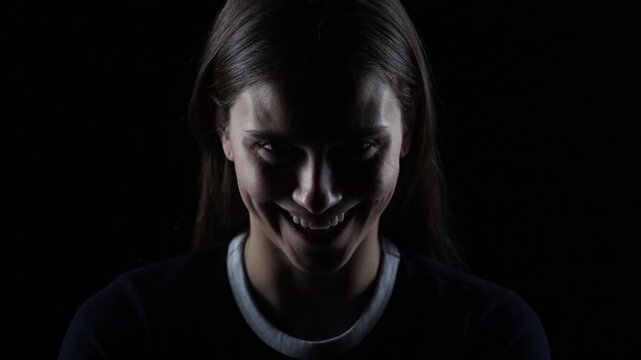 4K cinematic dark portrait of young woman laughing creepily with evil expression in dramatic lighting