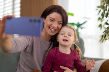 Mother and daughter taking selfie with smartphone smiling