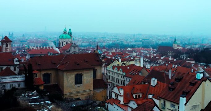 Wide winter overview of Prague Old Town from Strahov Monastery. Blue early morning atmosphere highlights historic architecture and iconic landmarks in a calm, cinematic cityscape.