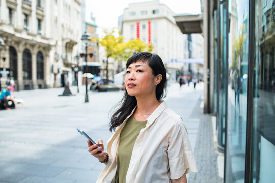 Portrait of woman using smartphone on urban street
