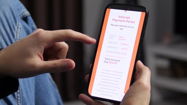Close-up of hands holding a phone with an internet billing interface. Concept of remote work, smart home management, and monthly subscription services. Ideal for telecommunications ads and digital